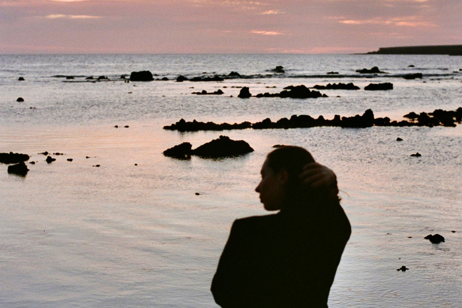 Femme seule devant la mer, semblant attendre quelqu'un ou quelque chose